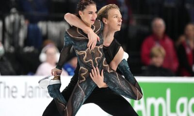 Georgian figure skater in a dynamic spin during competition, representing the nation's Olympic team medal ambitions.