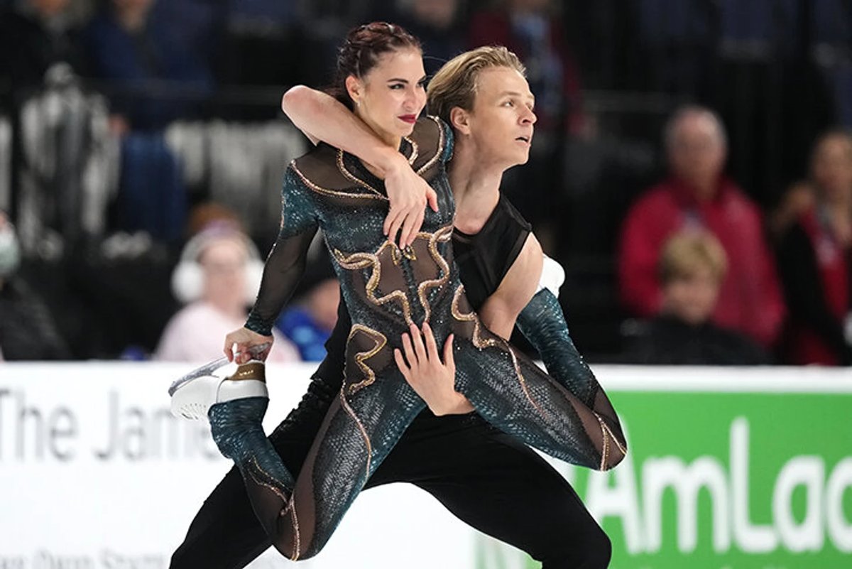 Georgian figure skater in a dynamic spin during competition, representing the nation's Olympic team medal ambitions.