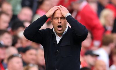 Liverpool and Manchester United players battling for the ball at Anfield during a tense Premier League match.