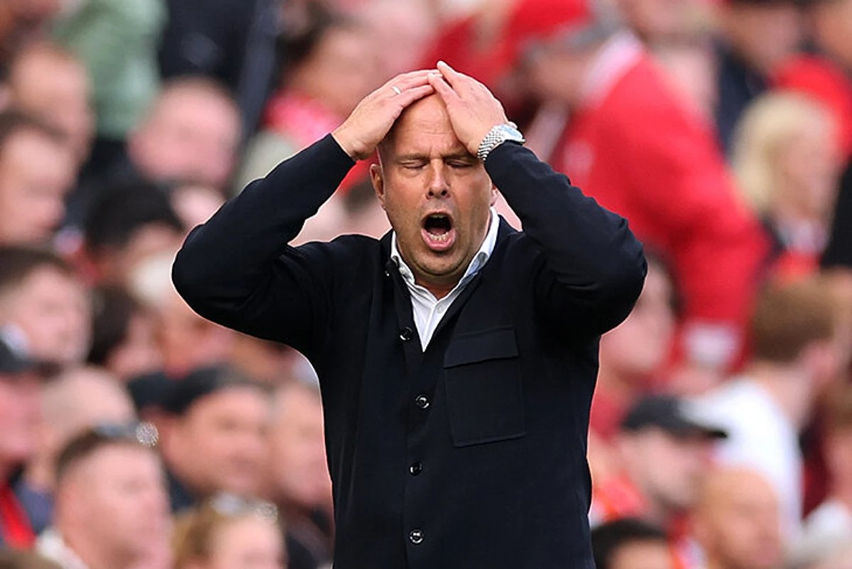 Liverpool and Manchester United players battling for the ball at Anfield during a tense Premier League match.