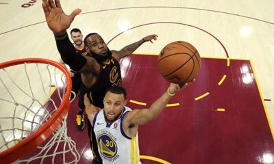 Bill Russell and Wilt Chamberlain facing off in a classic 1960s NBA game, debating their legendary legacies.