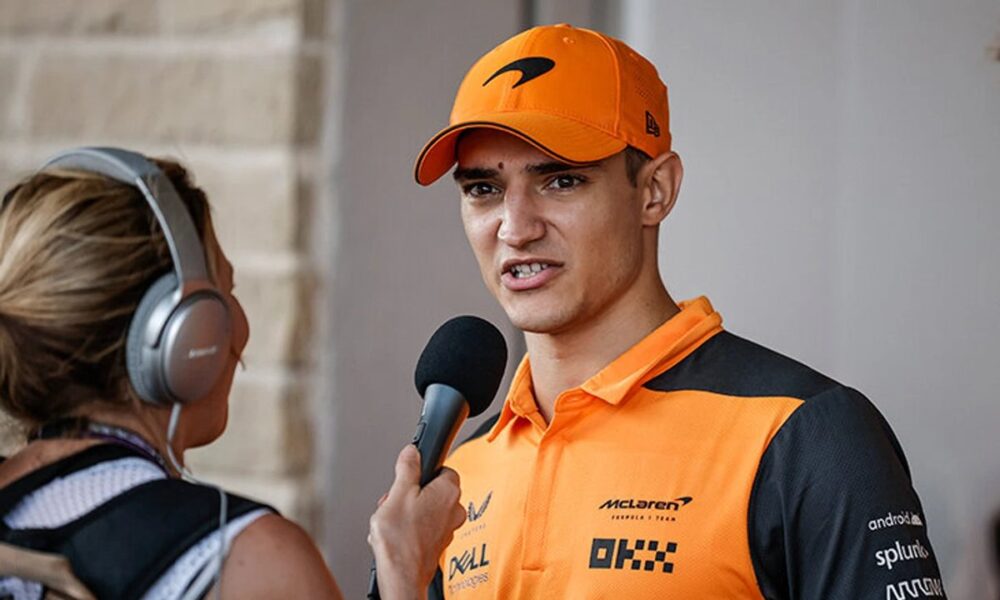 Alex Palou in racing suit with McLaren F1 car, facing $20 million lawsuit from the team.