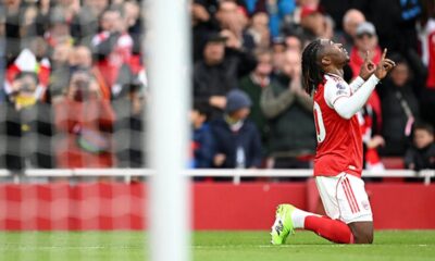 Arsenal players celebrating a goal as they lead the Premier League table over rivals Man City.