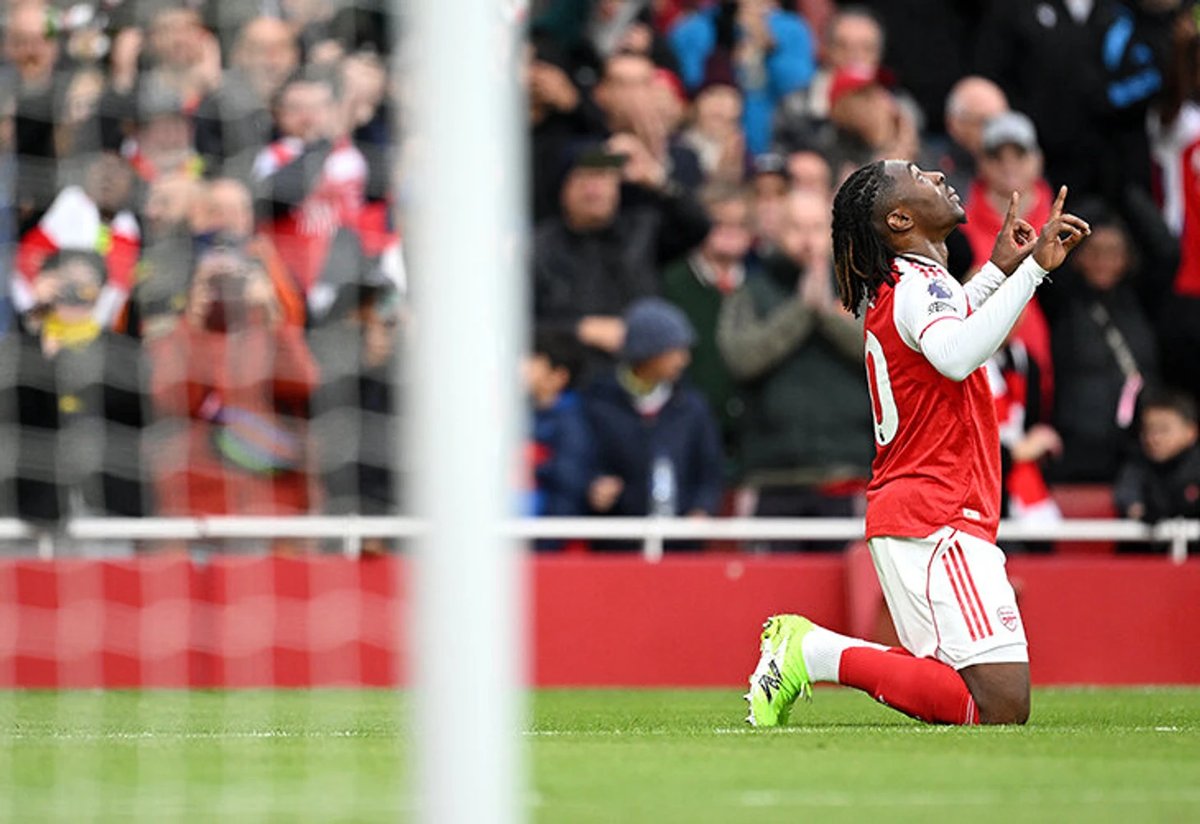 Arsenal players celebrating a goal as they lead the Premier League table over rivals Man City.
