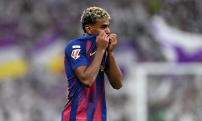 Lamine Yamal dribbles the ball during El Clásico, facing intense pressure from a Real Madrid defender.