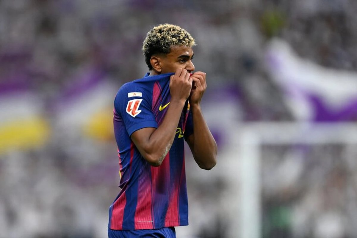 Lamine Yamal dribbles the ball during El Clásico, facing intense pressure from a Real Madrid defender.