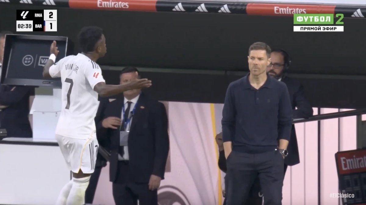Vinicius Junior reacts angrily after being substituted in El Clasico, showing frustration on the Real Madrid bench.