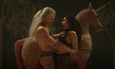 Geralt of Rivia in The Witcher Season 4, looking intense with silver sword drawn in a dark forest.