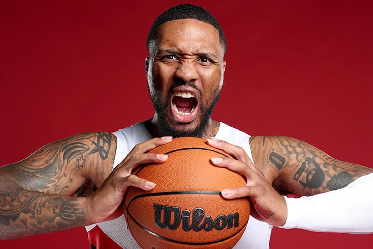 Doc Rivers on the Milwaukee Bucks sideline coaching Giannis Antetokounmpo and Damian Lillard during a game.